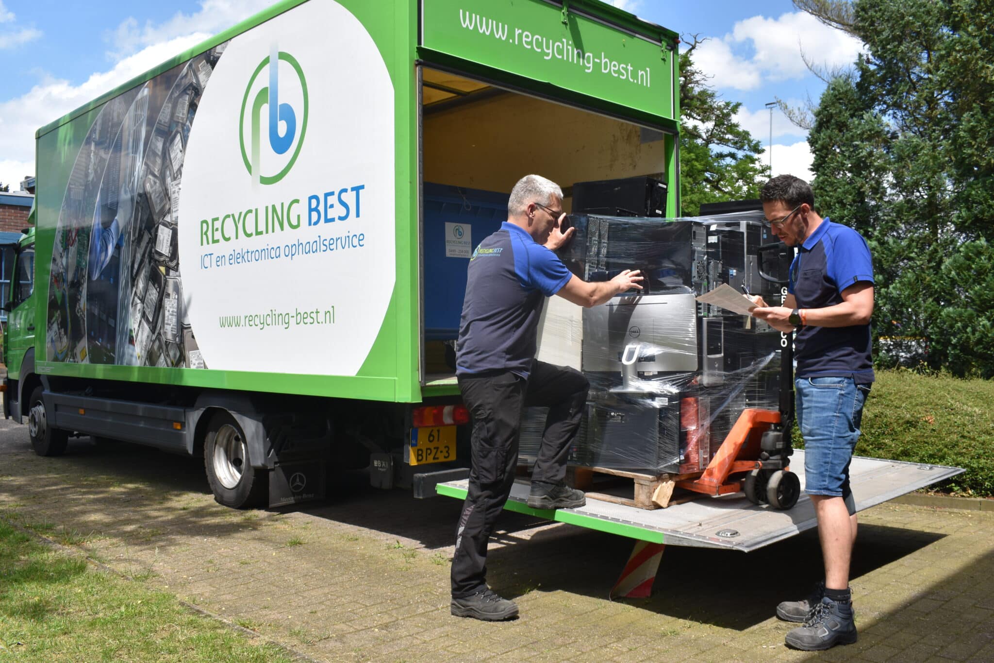 Recycling Best medewerkers die IT-afval in een vrachtwagen afvoeren - Recycling Best